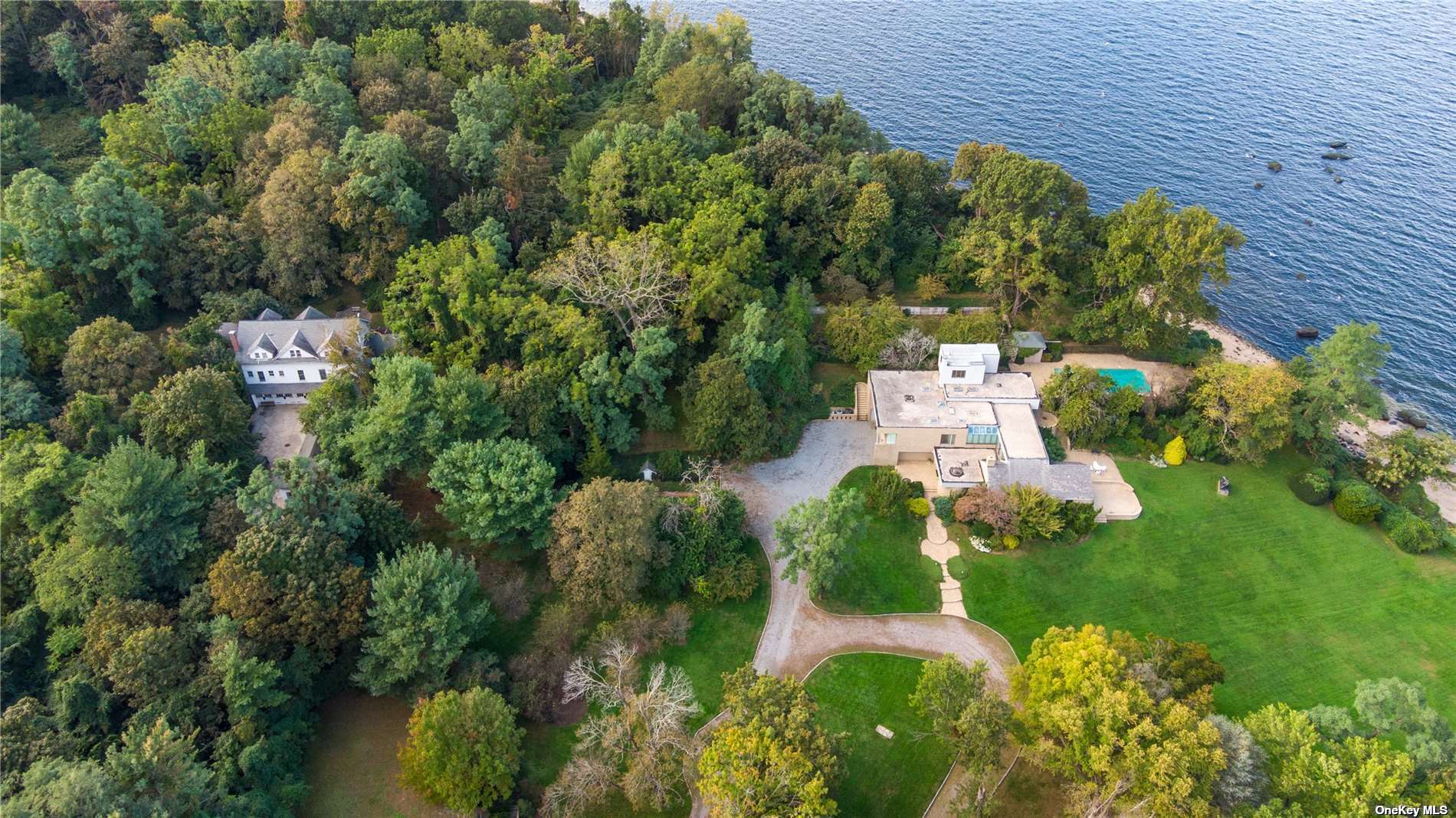 an aerial view of a house with a yard lake and outdoor seating