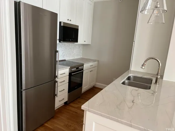 a kitchen with stainless steel appliances granite countertop a refrigerator sink and stove