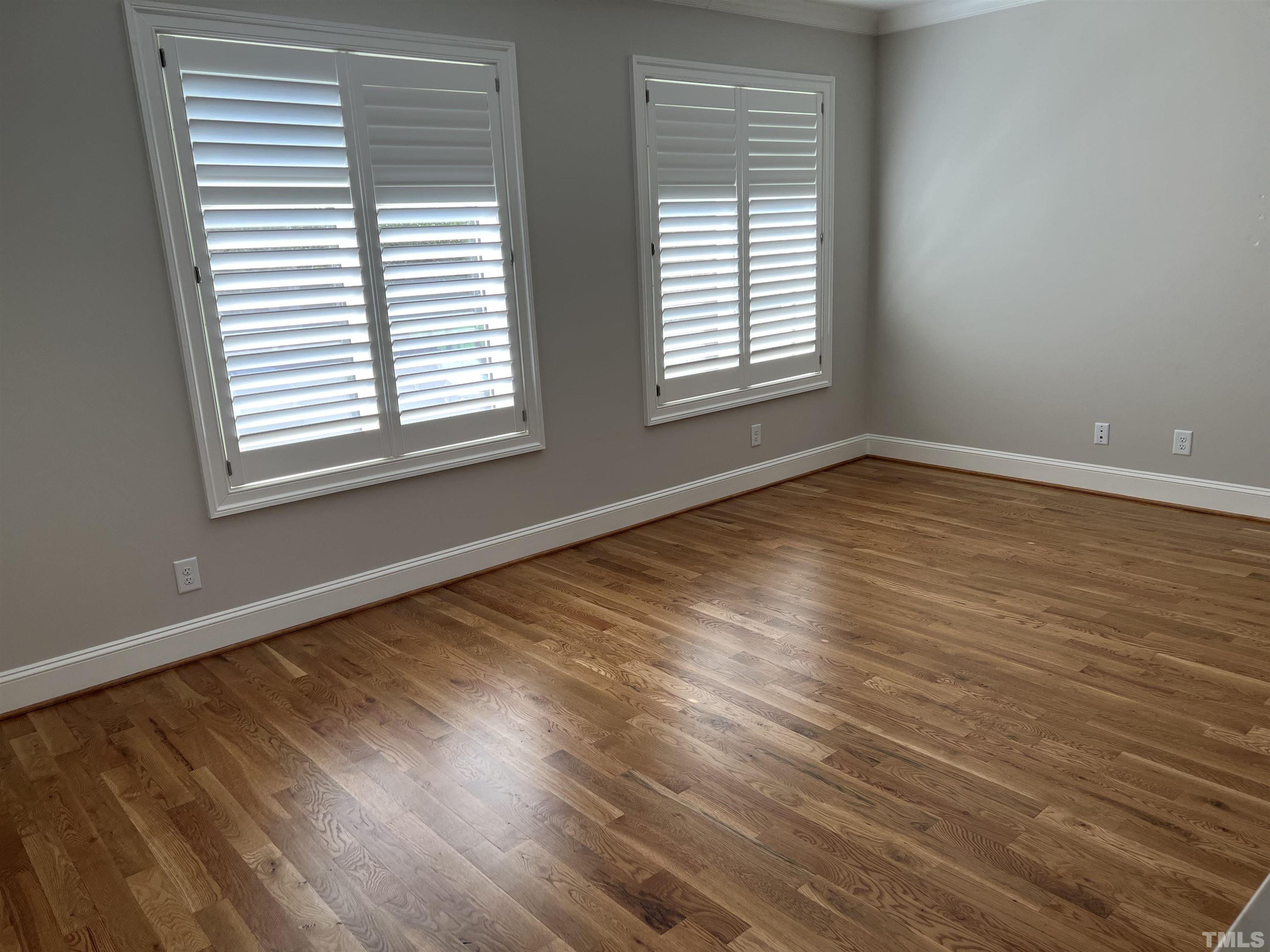 604 Daniels Street, Unit C Raleigh, NC 27605 - Photo 14 of 34 an empty room with wooden floor and windows