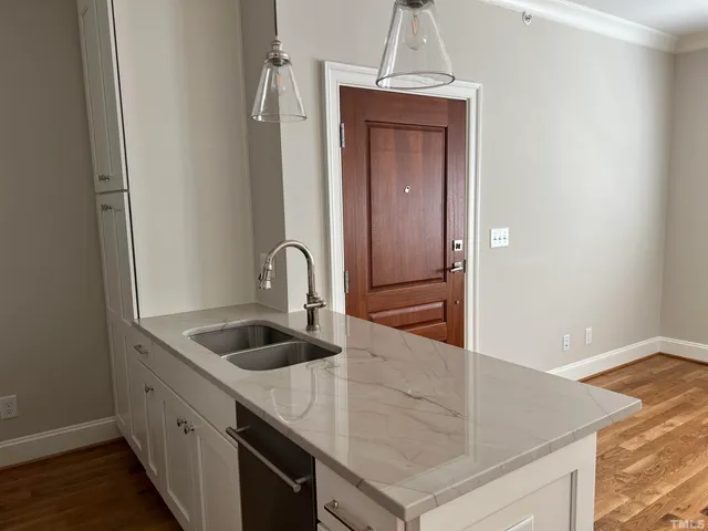 a kitchen with stainless steel appliances granite countertop a sink and a refrigerator