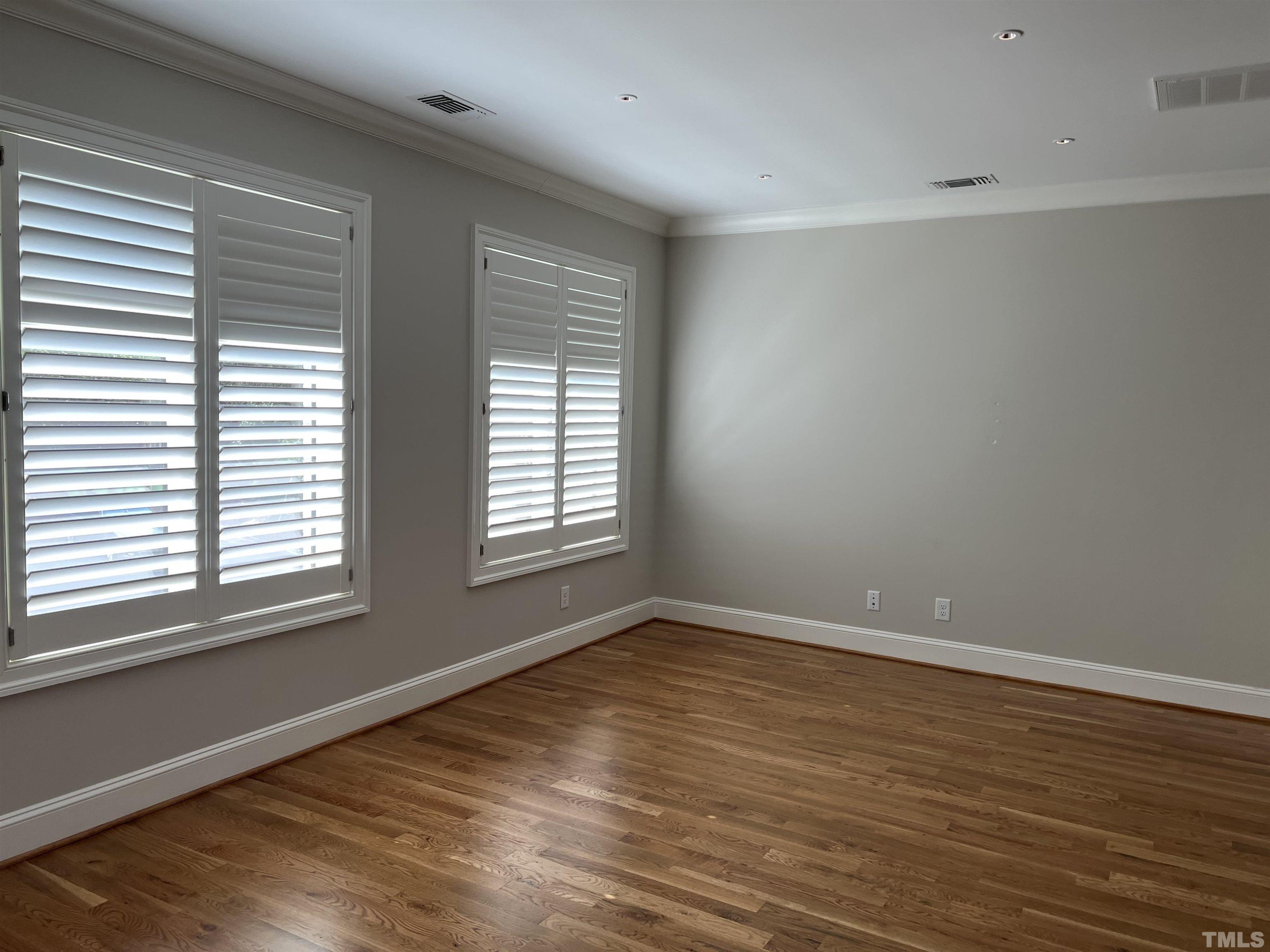 604 Daniels Street, Unit C Raleigh, NC 27605 - Photo 18 of 34 a view of an empty room with wooden floor and a window