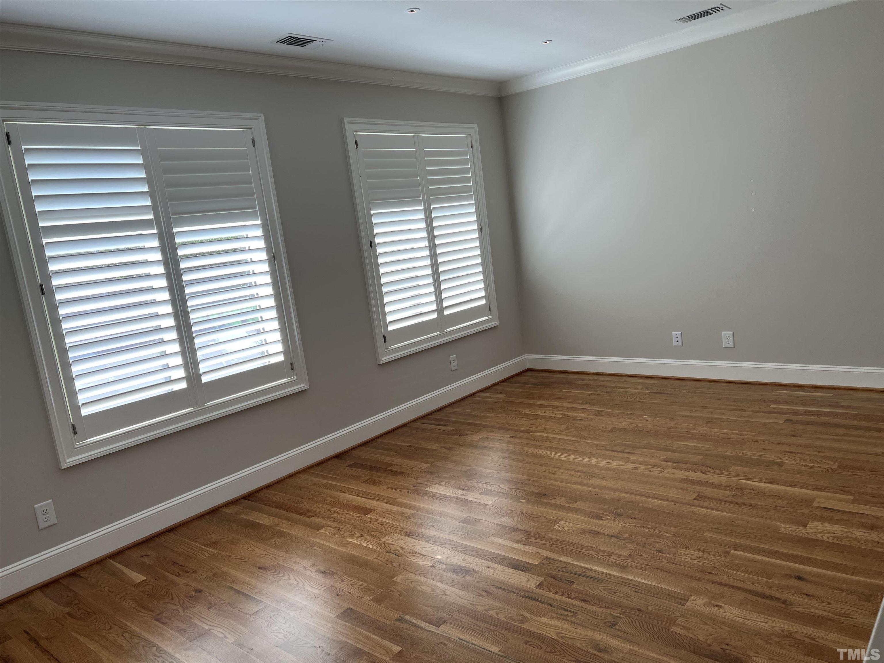 604 Daniels Street, Unit C Raleigh, NC 27605 - Photo 30 of 34 a view of an empty room with wooden floor and a window