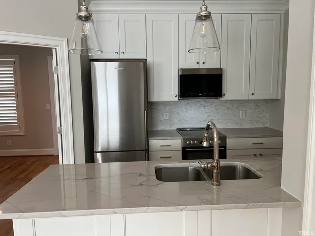 a kitchen with stainless steel appliances granite countertop a refrigerator and a stove
