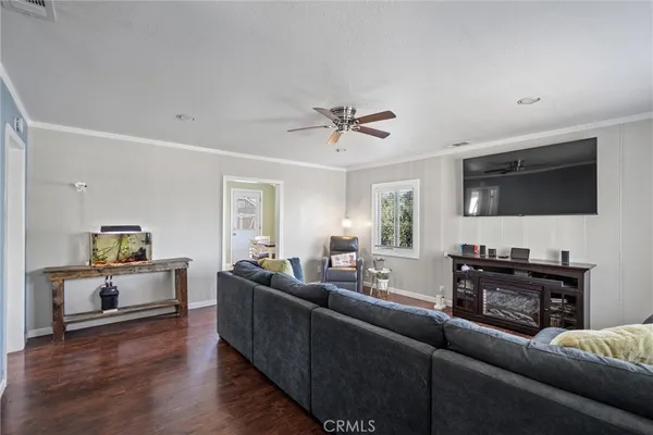 a living room with furniture flat screen tv and wooden floor