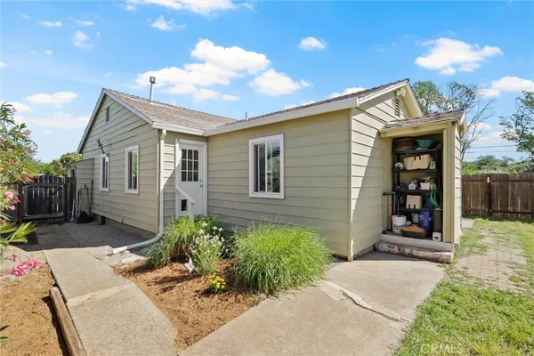 a white house with a yard and wooden fence