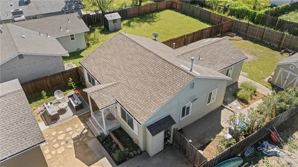 an aerial view of residential houses with outdoor space and trees