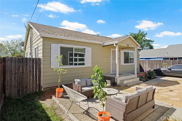 a view of a chair and table in backyard of the house