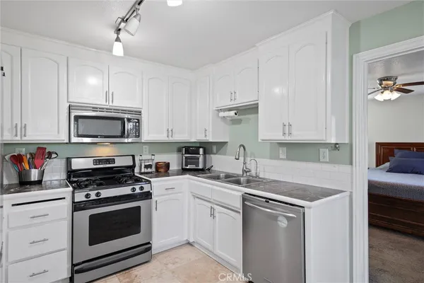 a kitchen with white cabinets stainless steel appliances and sink