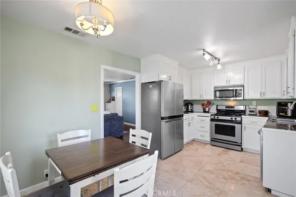 a kitchen with stainless steel appliances granite countertop a refrigerator a stove a sink dishwasher and a refrigerator with wooden floor