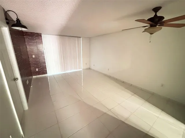 a view of a big room with windows and chandelier fan