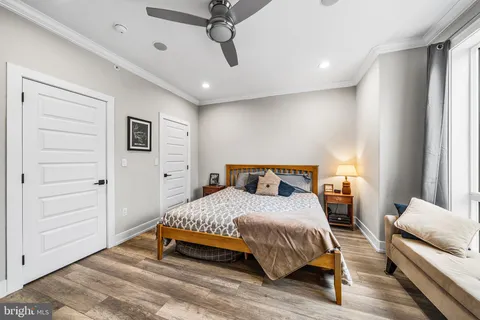 a bedroom with a bed and wooden floor