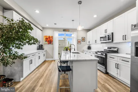 a kitchen with stainless steel appliances a white stove top oven a sink dishwasher and a refrigerator