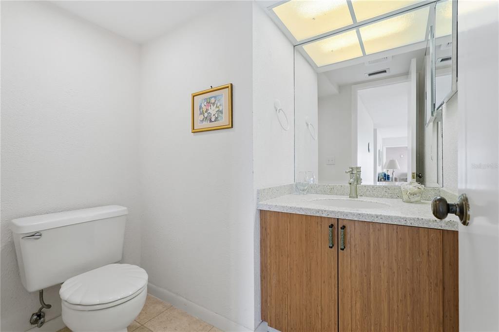 1500 Sunset Road, Unit C10 Tarpon Springs, FL 34689 - Photo 14 of 27 a bathroom with a granite countertop toilet a sink and mirror