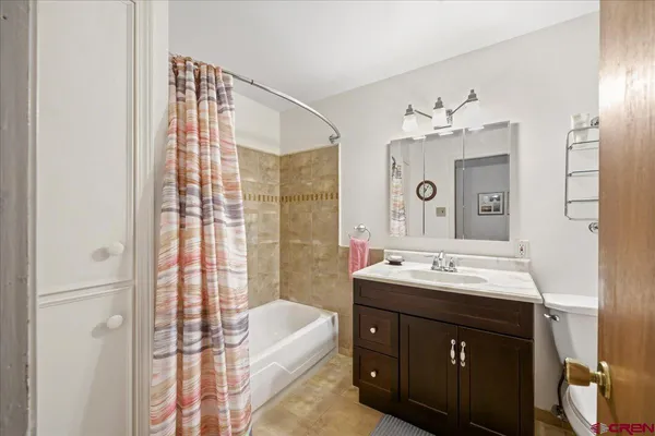 a spacious bathroom with a double vanity sink mirror and bathtub