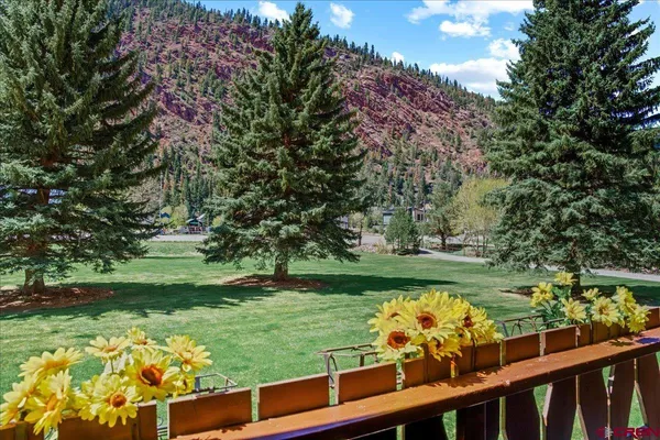a view of a garden with flowers and trees