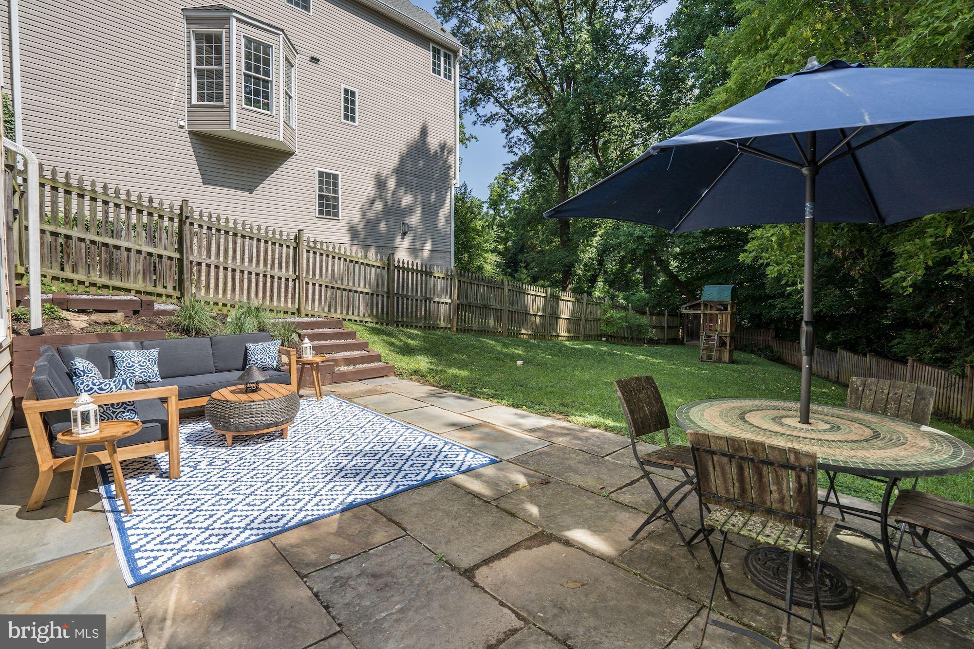 121 Ritchie Avenue Silver Spring, MD 20910 - Photo 50 of 65 a view of a patio with couches table and chairs under an umbrella