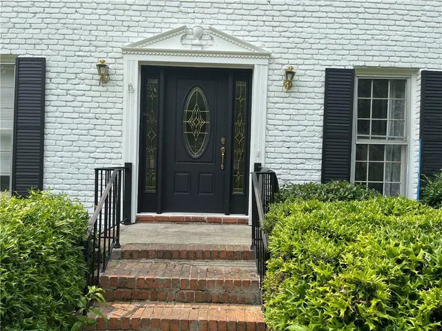a front view of a house with potted plants