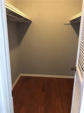 an empty room with wooden floor and closet
