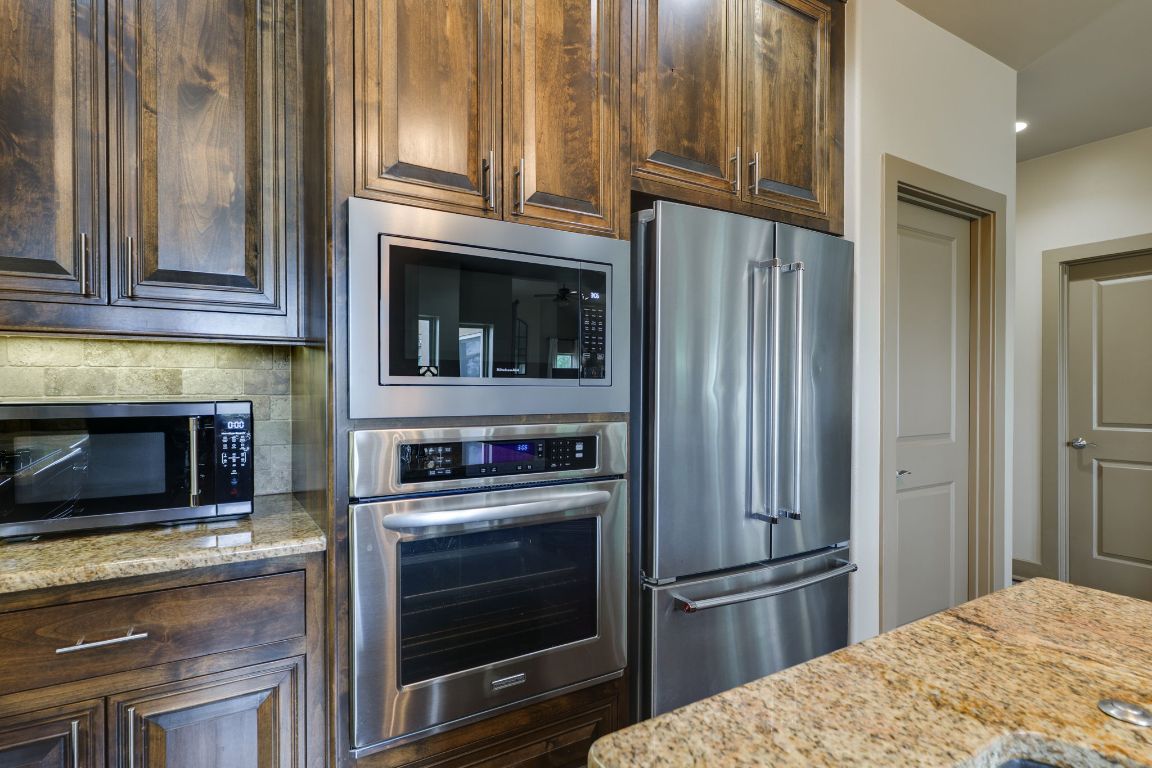 600 Mountain Dew Road Horseshoe Bay, TX 78657 - Photo 15 of 38 a kitchen with granite countertop a refrigerator stove and microwave