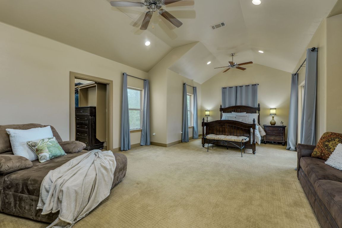 600 Mountain Dew Road Horseshoe Bay, TX 78657 - Photo 17 of 38 a spacious bedroom with a bed and a chandelier