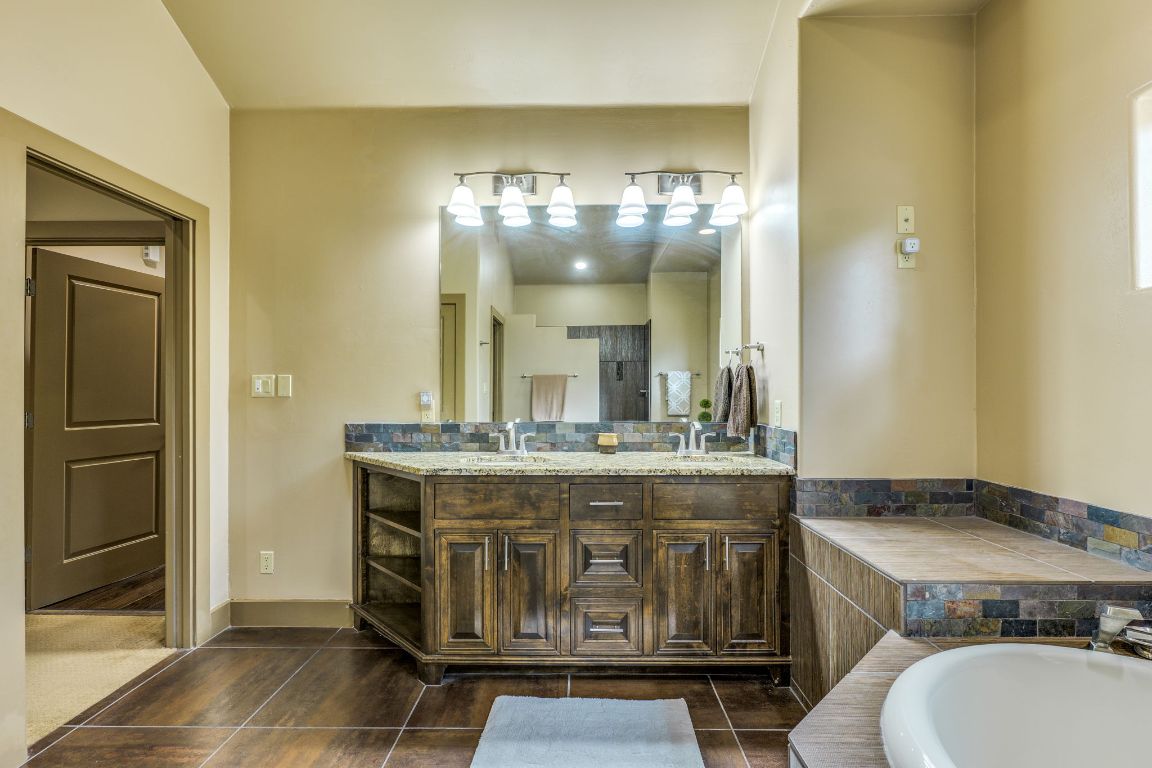 600 Mountain Dew Road Horseshoe Bay, TX 78657 - Photo 23 of 38 a bathroom with a granite countertop sink a toilet and a mirror