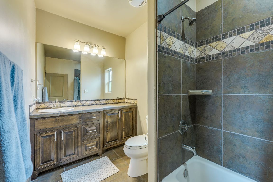 600 Mountain Dew Road Horseshoe Bay, TX 78657 - Photo 29 of 38 a bathroom with a granite countertop sink a toilet and a shower