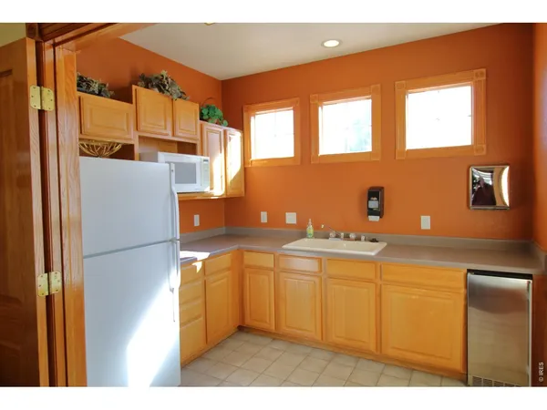 a kitchen with a sink a refrigerator and window