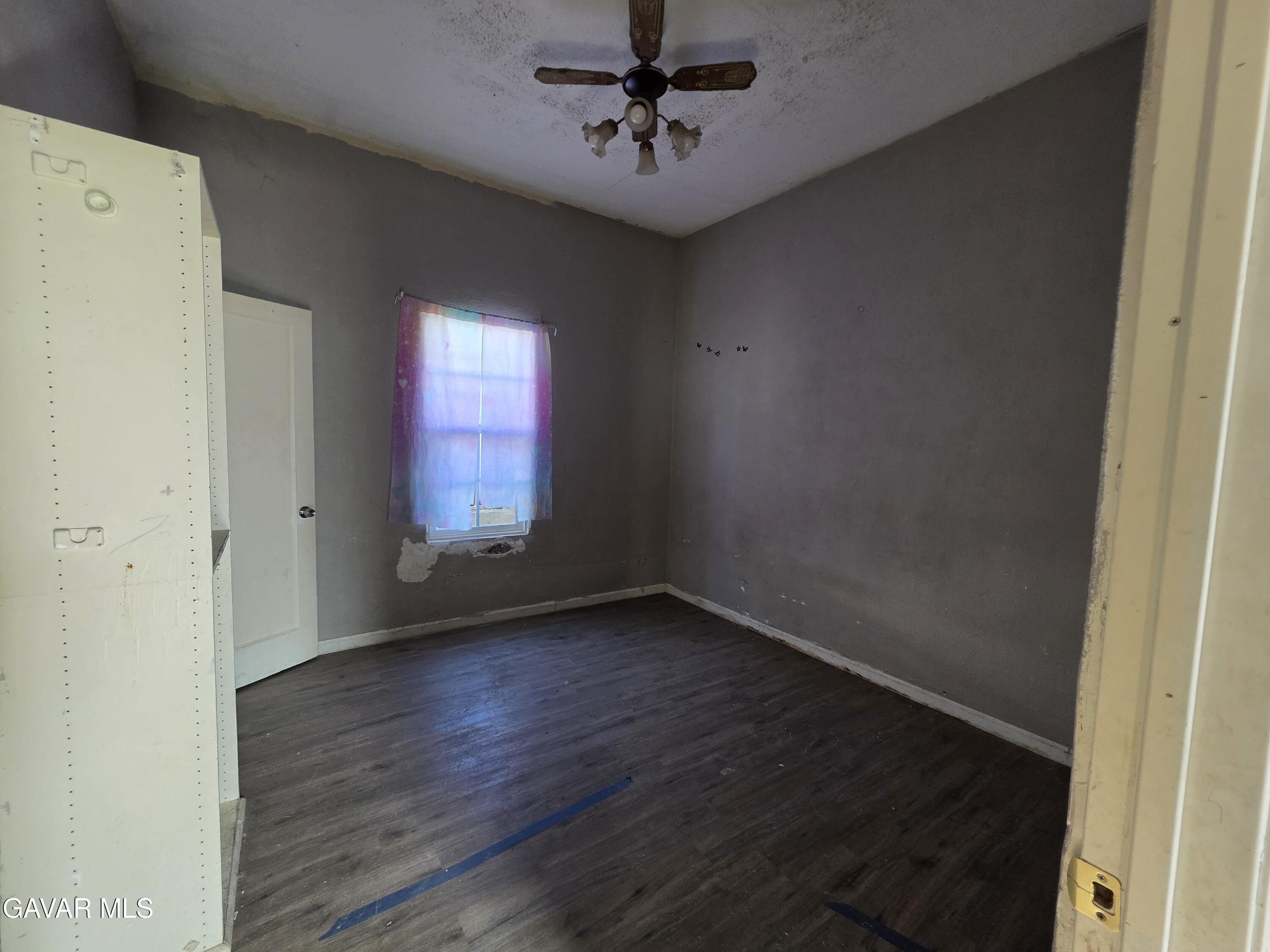 16133 I Street Mojave, CA 93501 - Photo 11 of 30 an empty room with wooden floor and windows