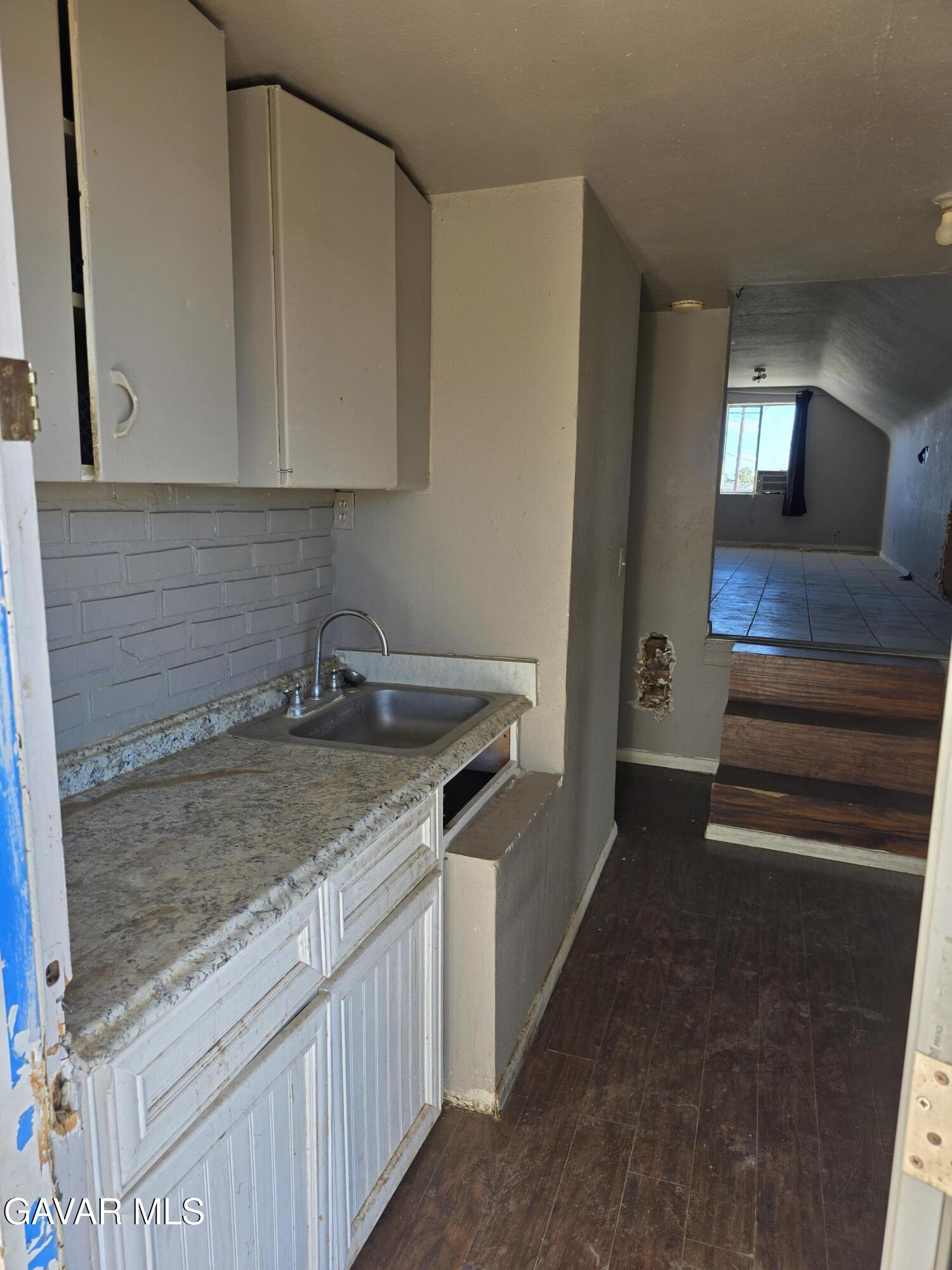 16133 I Street Mojave, CA 93501 - Photo 29 of 30 a kitchen with granite countertop a sink and a stove