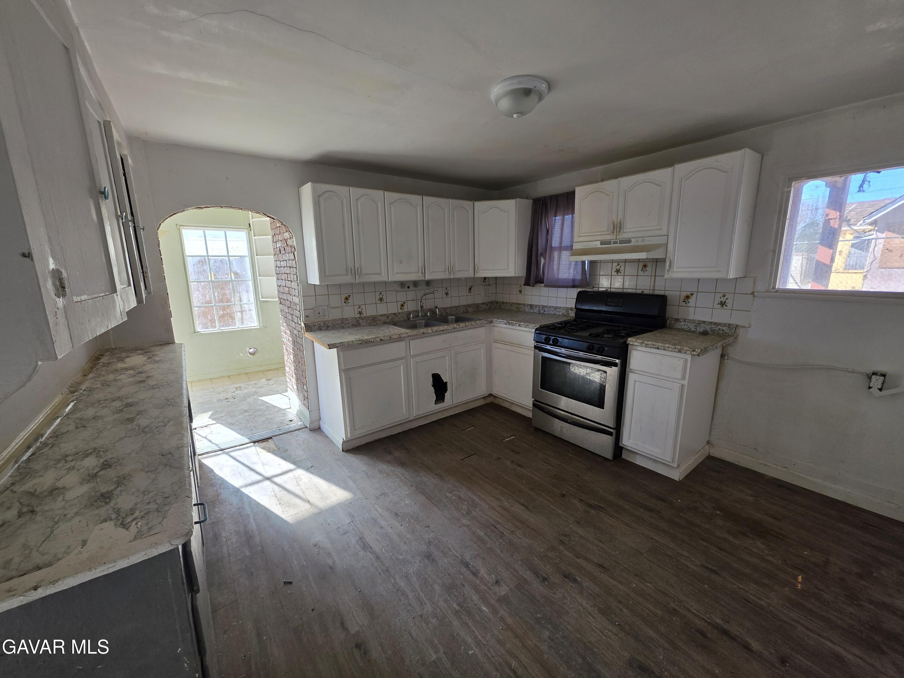 16133 I Street Mojave, CA 93501 - Photo 6 of 30 a kitchen with stainless steel appliances granite countertop a stove a sink and a refrigerator