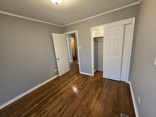 an empty room with wooden floor and closet