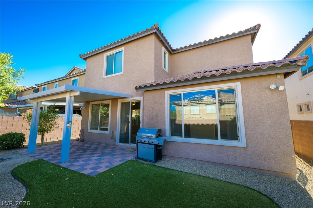 11016 Prairie Grove Road Las Vegas, NV 89179 - Photo 32 of 37 A private backyard oasis features a covered patio, artificial turf, and a built-in barbecue.