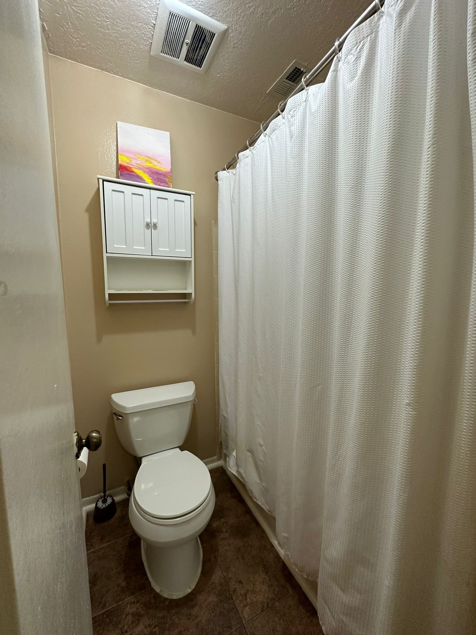 7305 South Gessner Road Houston, TX 77036 - Photo 22 of 24 a white toilet sitting next to a shower curtain