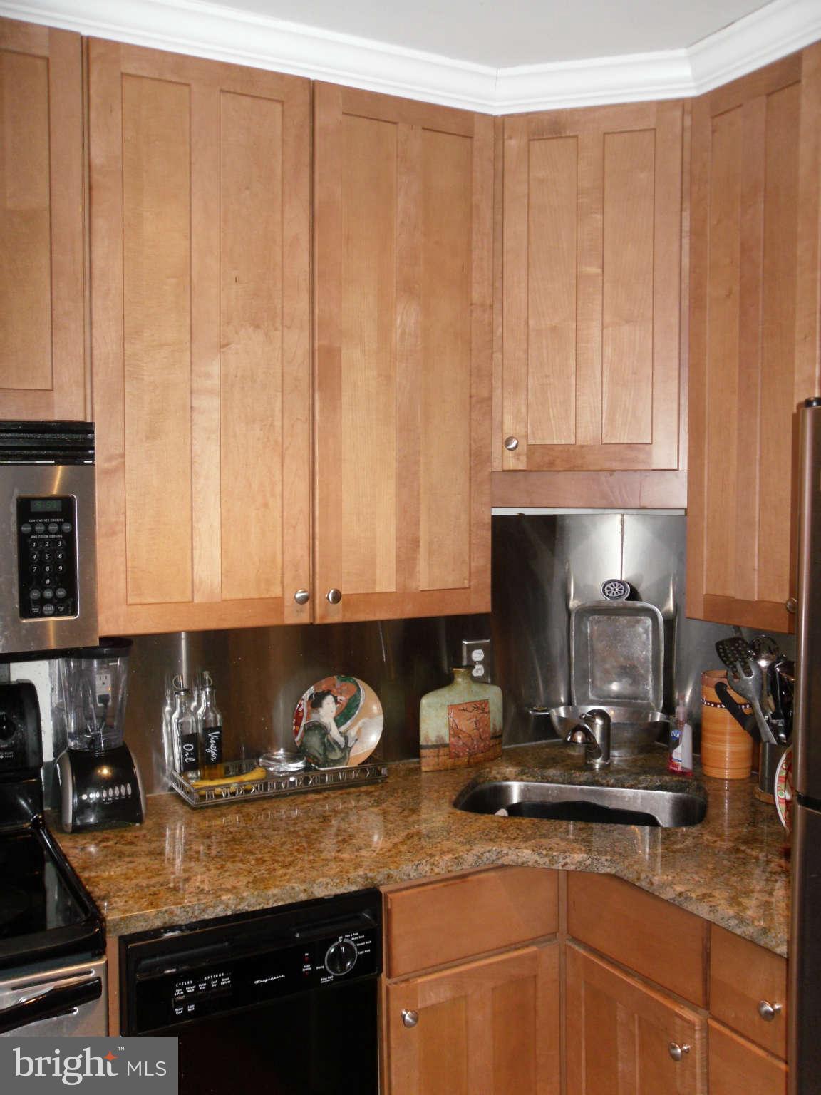 1435 4th Street Southwest, Unit B201 Washington, DC 20024 - Photo 5 of 22 a kitchen with granite countertop a sink a stove and cabinets