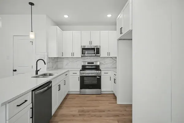 a kitchen with stainless steel appliances granite countertop a stove a sink and a refrigerator