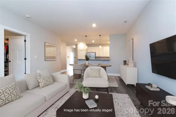 a living room with furniture a flat screen tv and a large window