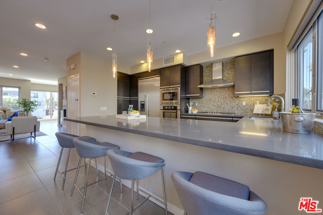 310 Washington Boulevard, Unit 802 Marina del Rey, CA 90292 - Photo 11 of 43 a large kitchen with a large counter top space a sink appliances and cabinets