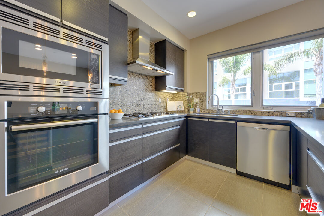 310 Washington Boulevard, Unit 802 Marina del Rey, CA 90292 - Photo 9 of 43 a kitchen with stainless steel appliances granite countertop a stove and a microwave