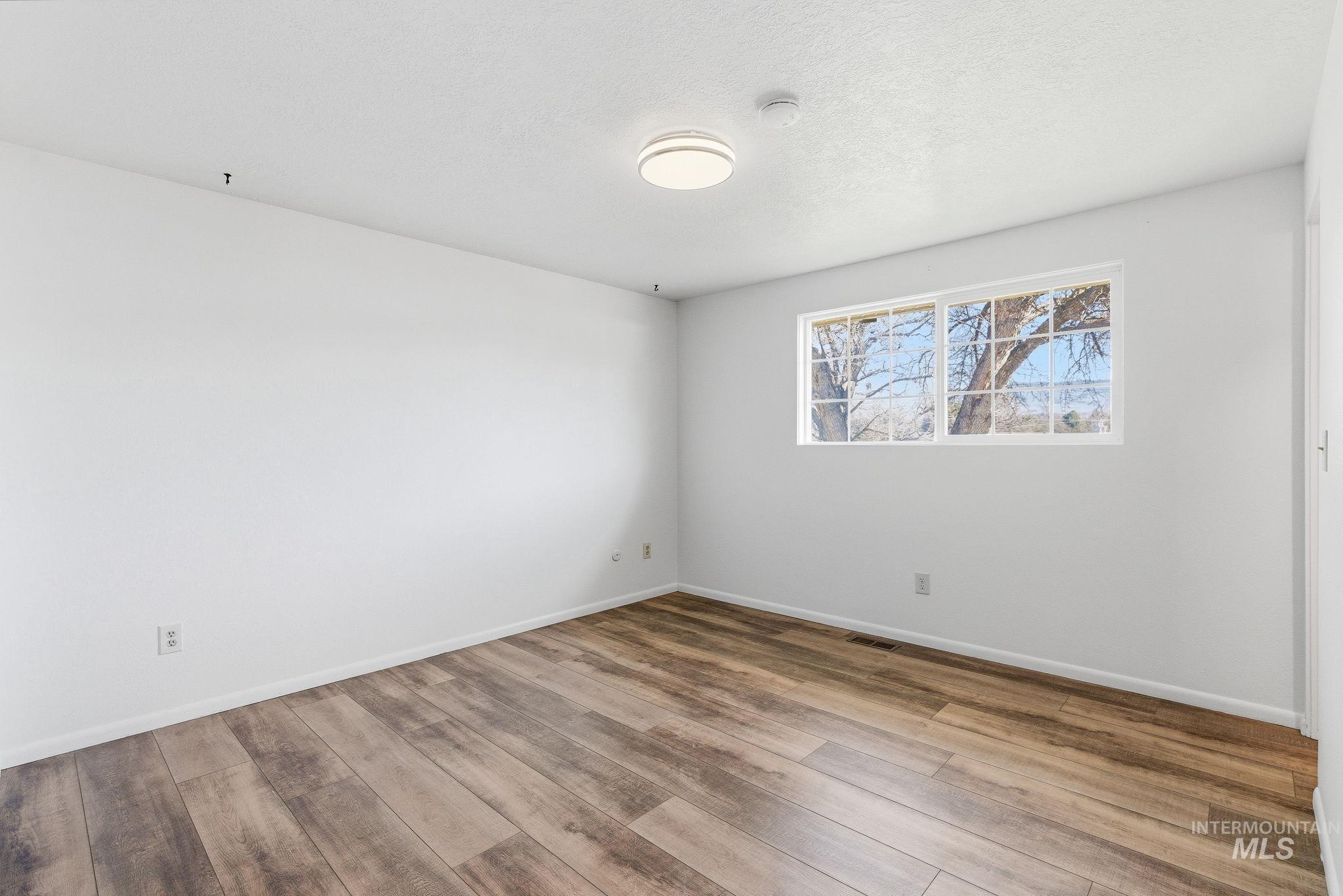 2072 South Crystal Way Boise, ID 83706 - Photo 19 of 50 Empty room featuring light wood-style floors and a textured ceiling