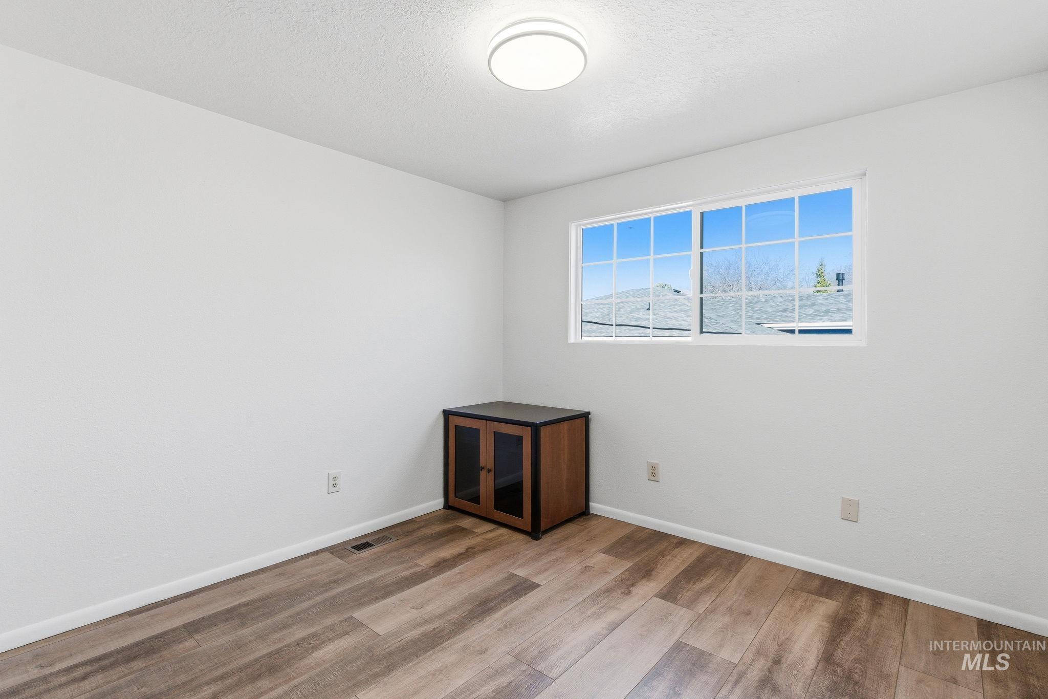 2072 South Crystal Way Boise, ID 83706 - Photo 21 of 50 Empty room with light wood finished floors and a textured ceiling