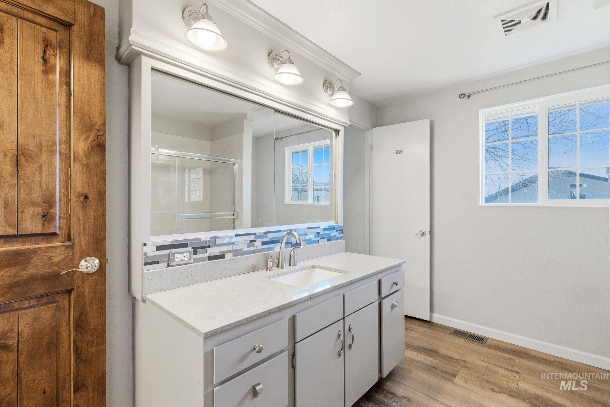 2072 South Crystal Way Boise, ID 83706 - Photo 24 of 50 Full bath with tasteful backsplash, vanity, light wood-style floors, a stall shower, and plenty of natural light