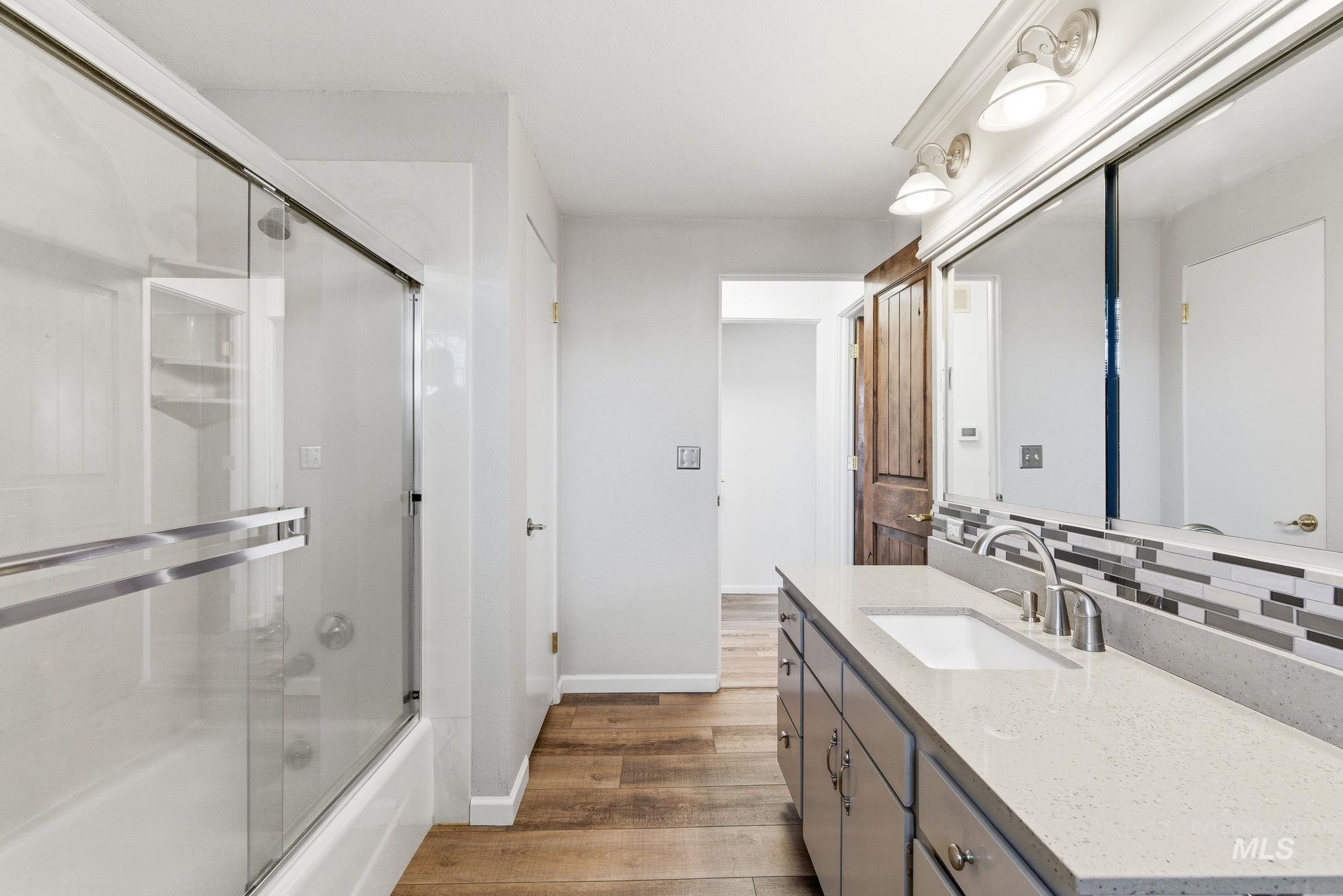 2072 South Crystal Way Boise, ID 83706 - Photo 25 of 50 Bathroom with vanity, combined bath / shower with glass door, and light wood-style floors