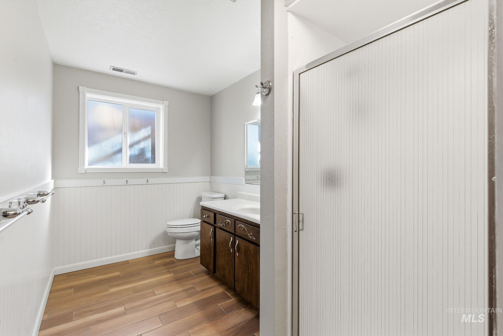 2072 South Crystal Way Boise, ID 83706 - Photo 40 of 50 Full bath featuring a wainscoted wall, a shower stall, light wood finished floors, and vanity