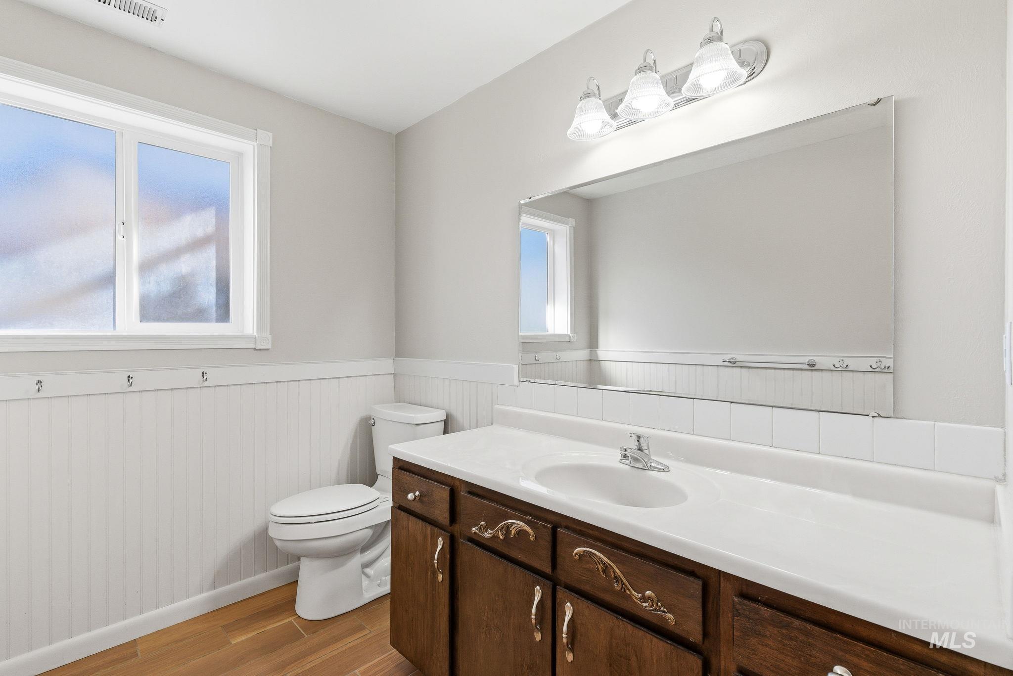 2072 South Crystal Way Boise, ID 83706 - Photo 41 of 50 Bathroom featuring vanity, a wainscoted wall, light wood-type flooring, and plenty of natural light