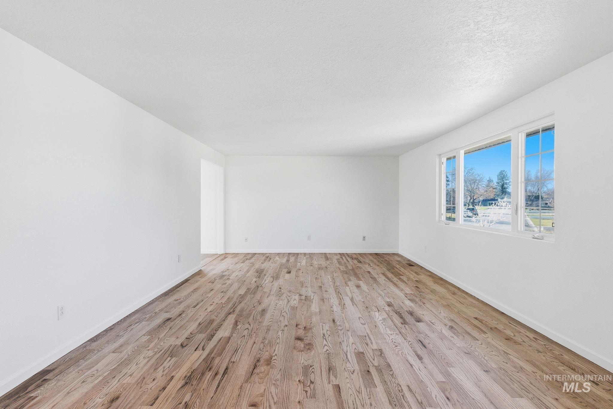 2072 South Crystal Way Boise, ID 83706 - Photo 6 of 50 Empty room with light wood-style floors and a textured ceiling