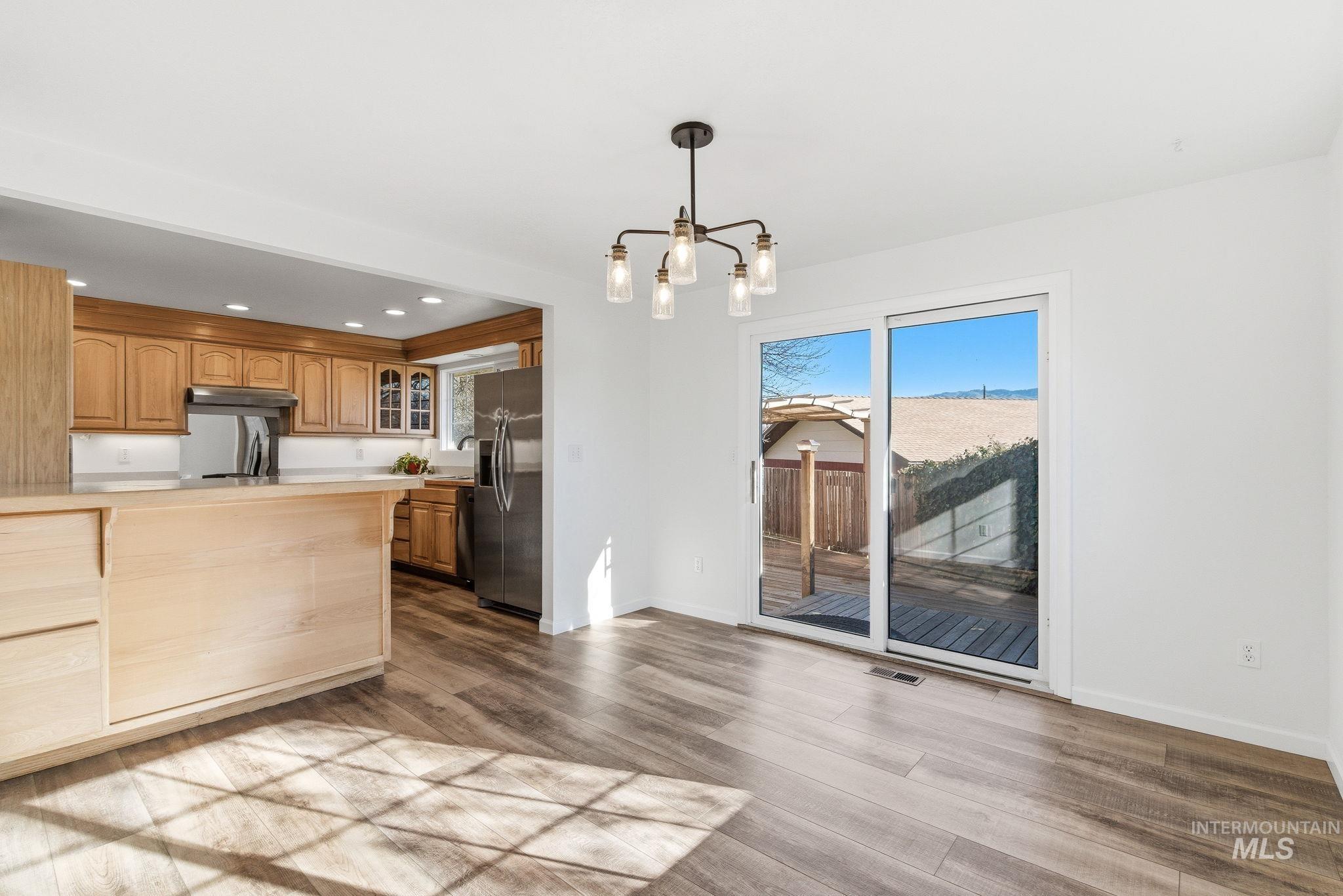 2072 South Crystal Way Boise, ID 83706 - Photo 9 of 50 Kitchen with glass fronted cabinets, plenty of natural light, light countertops, and stainless steel fridge with ice dispenser
