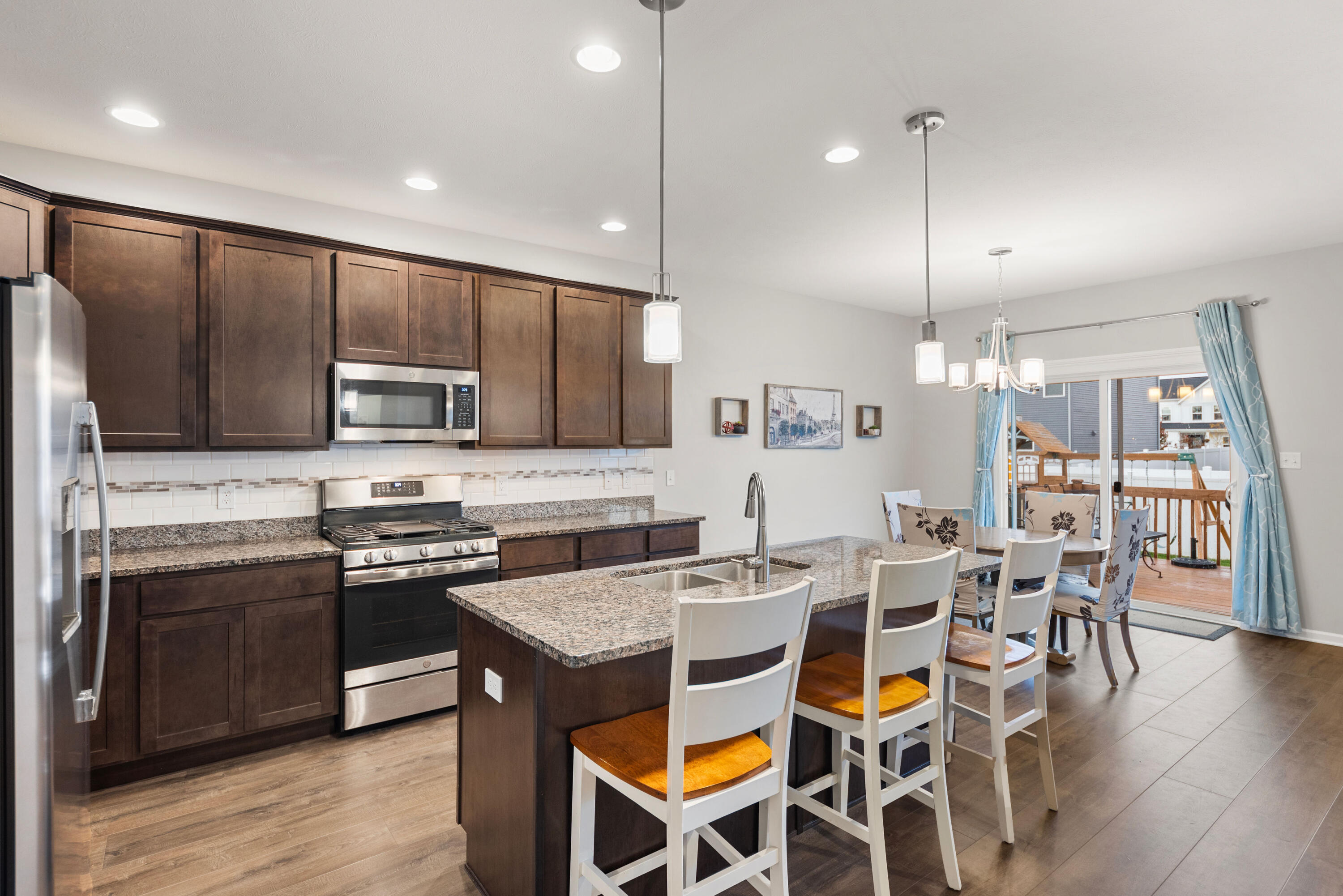 2451 Ritter Street Chesterton, IN 46304 - Photo 3 of 18 a kitchen with stainless steel appliances kitchen island granite countertop a stove a refrigerator a sink a dining table and chairs with wooden floor