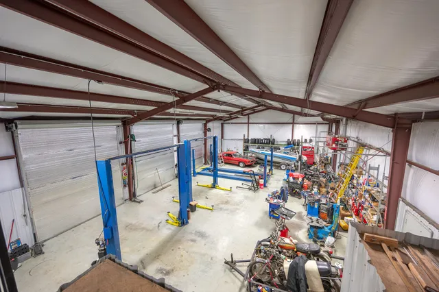 a living room with stainless steel appliances furniture and a kitchen view