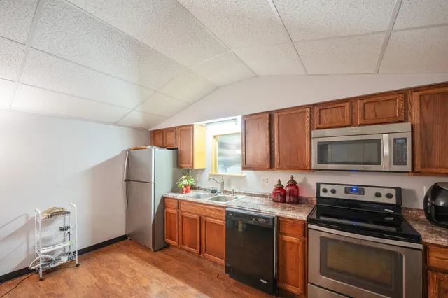a bedroom with a bed a dresser and wooden floor