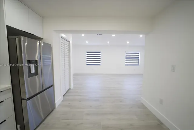 a view of a hallway with stainless steel appliances